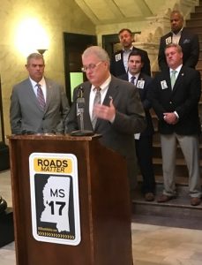 Speaker of the House Philip Gunn looks on as MEC COO Scott Waller speaks at an MEC news conference yesterday explaining how the House plan for fixing Mississippi's crumbling roads and bridges will make a difference.